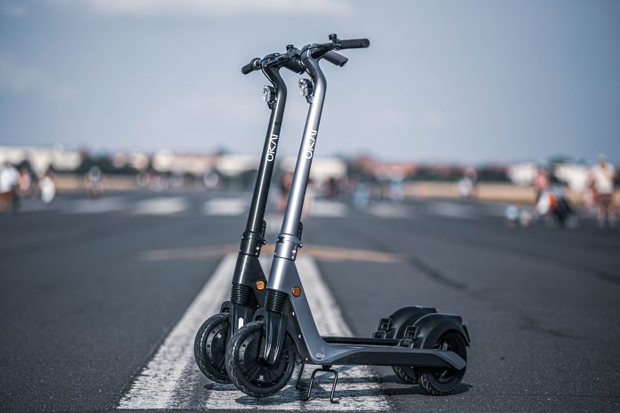 Two electric scooters on the road.